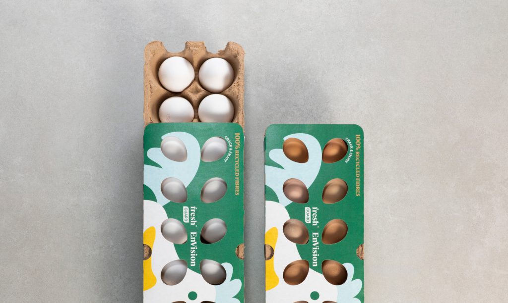 Two open cartons of eggs—white on the left, brown on the right—sit on a light gray surface. Both green with floral designs, these cartons hint at innovative packaging from an agence de développement de produits à Montréal.