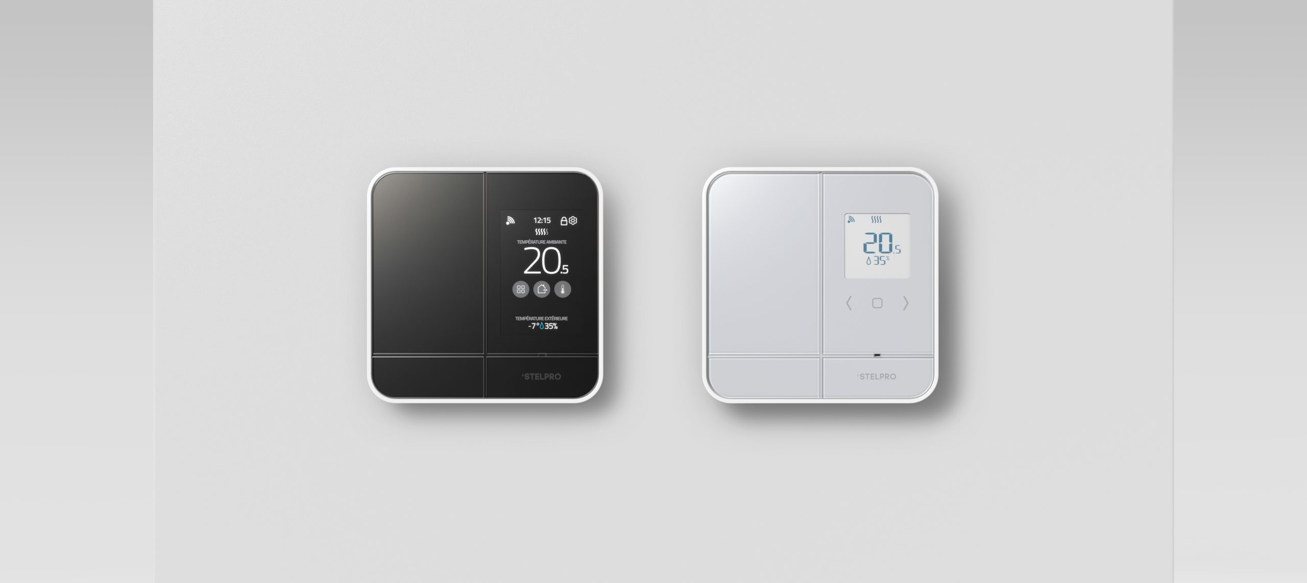 Two modern digital thermostats are mounted on a light grey wall—ideal for showcasing la stratégie de design au Québec, with one featuring a black touchscreen and the other a sleek white casing with a blue digital screen.