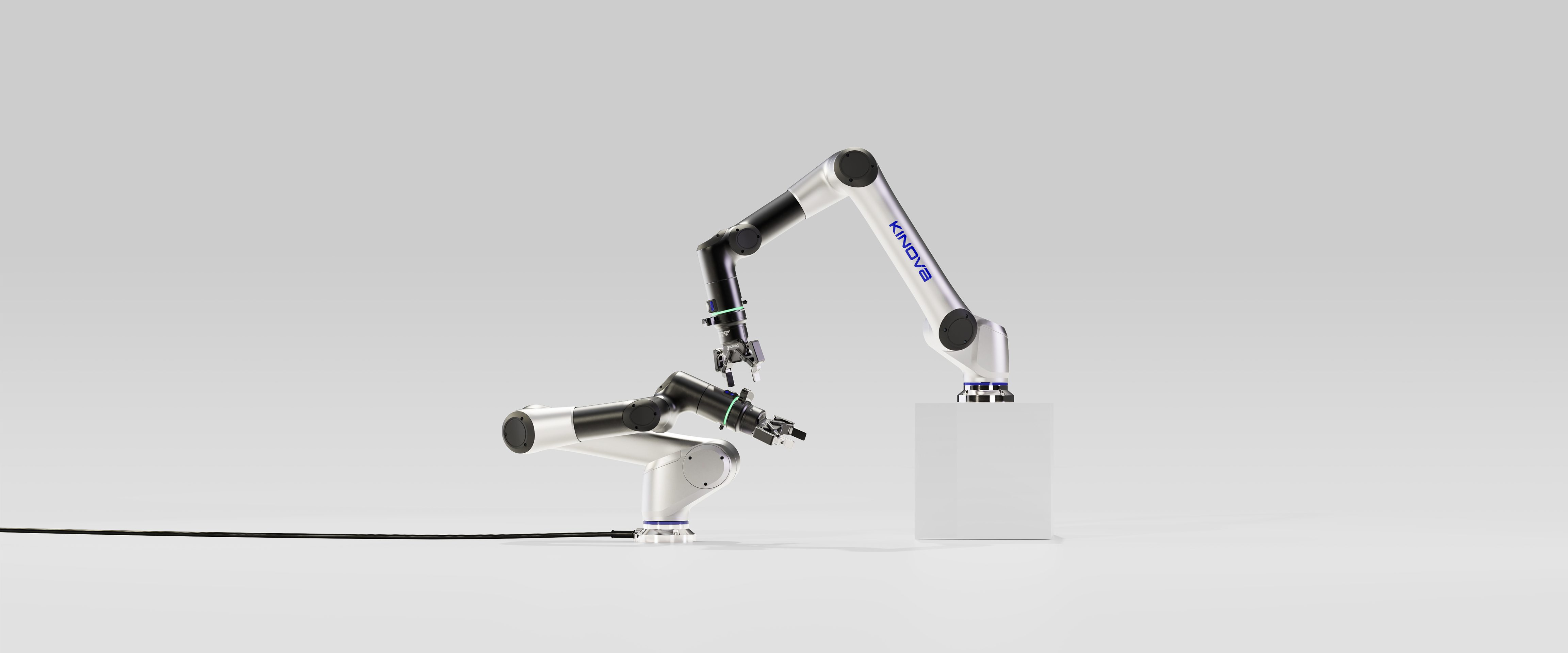 Un bras robotique industriel blanc et noir étiqueté HANSON, conçu par une agence de développement de produits à Montréal, saisit un petit objet tout en s'étendant vers un bloc blanc sur fond gris. Un câble part de la base du robot.