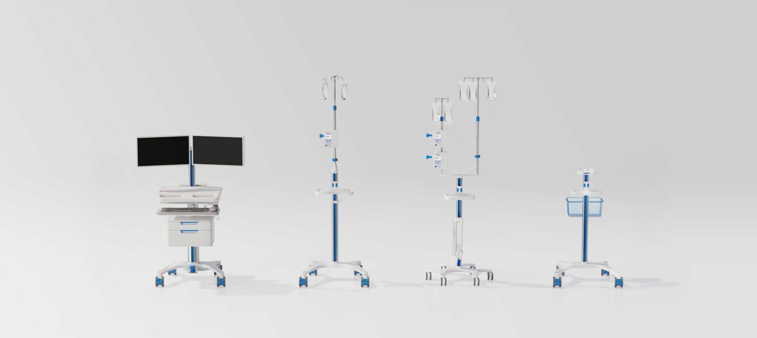 Four mobile hospital workstation units are lined up side by side against a plain light background. Designed with a blue and white base on wheels, each unit—reflecting la stratégie de design au Québec—holds various medical equipment or screens.