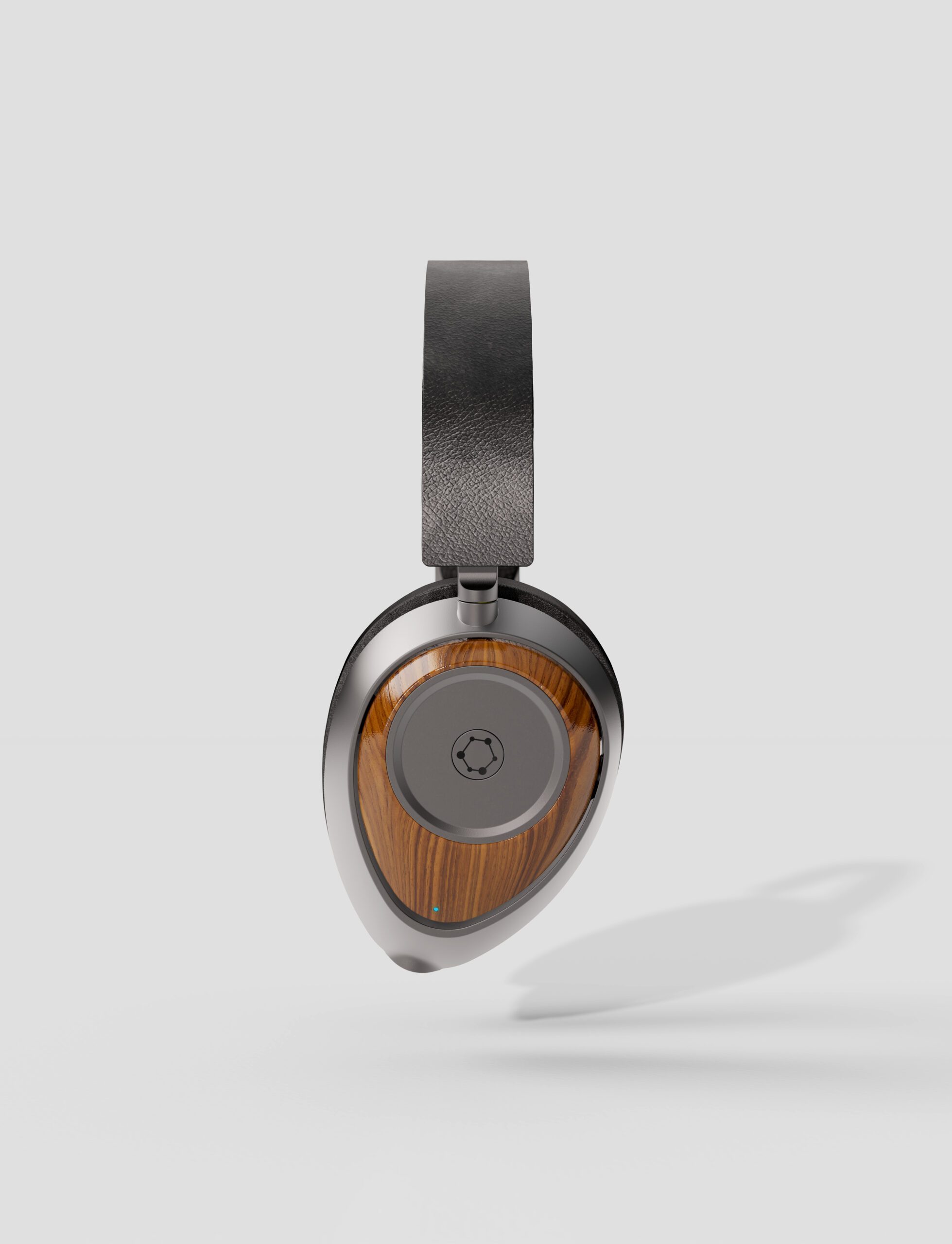 A single over-ear headphone with a black headband, silver accents, and a wooden outer earcup—expertly crafted by an agence de design industriel à Montréal—displayed against a plain light gray background with a faint shadow.